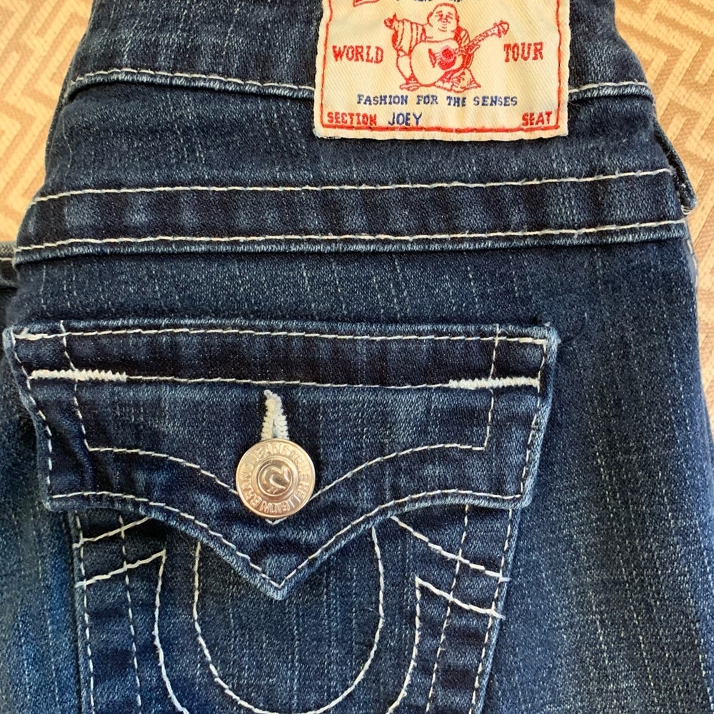 True Religion “Joey” Jeans, lower rise, form fitting, flared at leg opening.